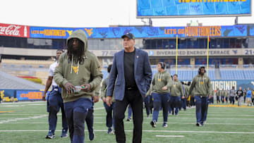 Nov 8, 2025; Morgantown, West Virginia, USA; West Virginia Mountaineers head coach Rich Rodriguez walks with his team as they arrive before their game against the Colorado Buffaloes at Milan Puskar Stadium. Mandatory Credit: Ben Queen-Imagn Images