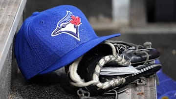 Apr 16, 2025; Toronto, Ontario, CAN; A Toronto Blue Jays hat and glove in the dugout during a game against the Atlanta Braves at Rogers Centre. Mandatory Credit: John E. Sokolowski-Imagn Images