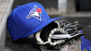 Apr 16, 2025; Toronto, Ontario, CAN; A Toronto Blue Jays hat and glove in the dugout during a game against the Atlanta Braves at Rogers Centre. Mandatory Credit: John E. Sokolowski-Imagn Images
