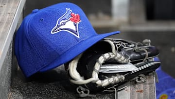 Apr 16, 2025; Toronto, Ontario, CAN; A Toronto Blue Jays hat and glove in the dugout during a game against the Atlanta Braves at Rogers Centre. John E. Sokolowski-Imagn Images