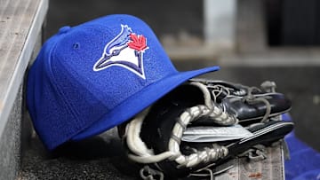 Apr 16, 2025; Toronto, Ontario, CAN; A Toronto Blue Jays hat and glove in the dugout during a game against the Atlanta Braves at Rogers Centre. Mandatory Credit: John E. Sokolowski-Imagn Images