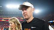 Nov 29, 2025; Los Angeles, California, USA; Southern California Trojans head coach Lincoln Riley walks with wife Caitlin Riley after the game against the UCLA Bruins at United Airlines Field at Los Angeles Memorial Coliseum. Mandatory Credit: Kirby Lee-Imagn Images