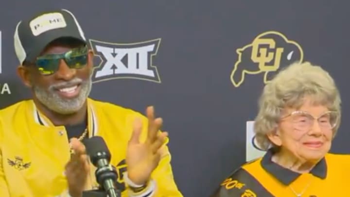 Colorado football coach Deion Sanders speaks to the media with Buffaloes superfan Miss Peggy seated next to him on November 19, 2024. Colorado football coach Deion Sanders speaks to the media with Buffaloes superfan Miss Peggy seated next to him on November 19, 2024.