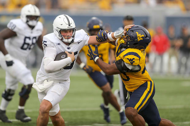 Quarterback stiff arms defender.