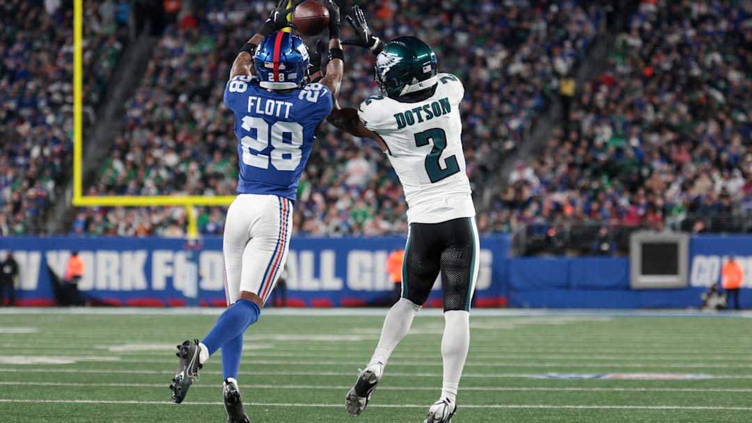 Oct 9, 2025; East Rutherford, New Jersey, USA; New York Giants cornerback Cor'Dale Flott (28) intercepts the pass intended for Philadelphia Eagles wide receiver Jahan Dotson (2) during the fourth quarter of the game at MetLife Stadium. Mandatory Credit: Vincent Carchietta-Imagn Images