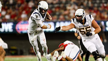 Oct 26, 2024; Tucson, Arizona, USA; West Virginia Mountaineers quarterback Nicco Marchiol (8) runs with the ball and gets tripped by Arizona Wildcats defender during the third quarter Arizona Stadium. Mandatory Credit: Aryanna Frank-Imagn Images