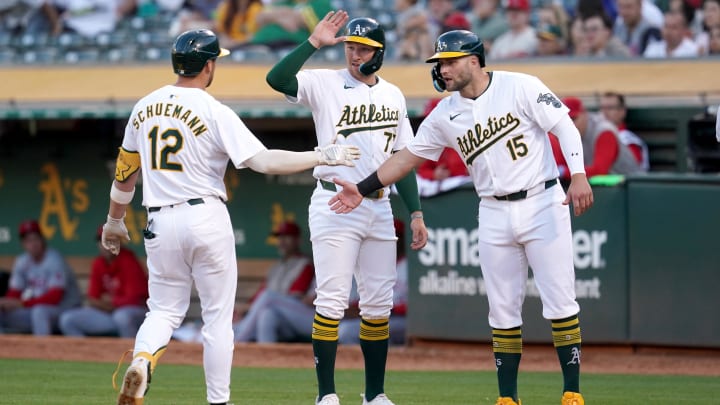 Jul 19, 2024; Oakland, California, USA; Oakland Athletics shortstop Max Schuemann (12) is congratulated by third baseman Brett Harris (77) and first baseman Seth Brown (15) after hitting a three-run home run against the Los Angeles Angels in the fourth inning at Oakland-Alameda County Coliseum. Mandatory Credit: Cary Edmondson-USA TODAY Sports