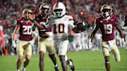 Oct 4, 2025; Tallahassee, Florida, USA; Miami Hurricanes wide receiver Malachi Toney (10) scores a touchdown against Florida State Seminoles defensive back Earl Little Jr. and defensive back Jerry Wilson (19) during the second half at Doak S. Campbell Stadium. Mandatory Credit: Robert Myers-Imagn Images