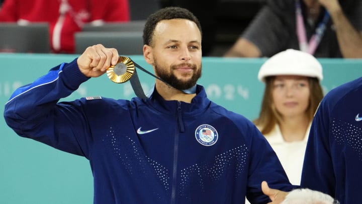 United States guard Steph Curry celebrates with the gold medal after defeating France in the men's basketball gold medal game.