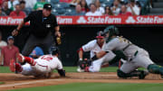 Jul 25, 2024; Anaheim, California, USA;  Los Angeles Angels center fielder Kevin Pillar (12) slides safely into home ahead of  a tag from Oakland Athletics catcher Shea Langeliers (23) during the second inning at Angel Stadium. Mandatory Credit: Kiyoshi Mio-USA TODAY Sports