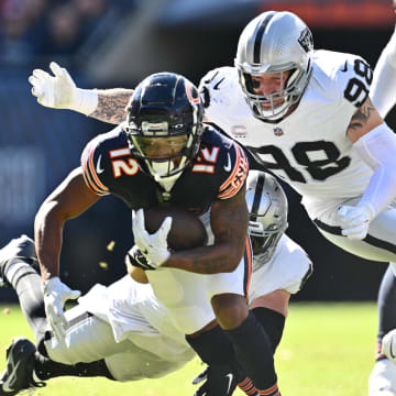 Oct 22, 2023; Chicago, Illinois, USA;  Chicago Bears wide receiver Velus Jones Jr. II (12) is brought down by Las Vegas Raiders defensive end Maxx Crosby (98) and linebacker Robert Spillane (41) after a short gain in the first quarter at Soldier Field. Mandatory Credit: Jamie Sabau-USA TODAY Sports