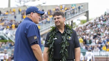 Sep 6, 2025; Athens, Ohio, USA; Ohio Bobcats head coach Brian Smith, right, talks with West Virginia Mountaineers head coach Rich Rodriguez prior to the game at Peden Stadium. Mandatory Credit: Ben Queen-Imagn Images