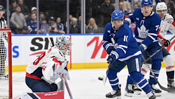 Dec 28, 2024; Toronto, Ontario, CAN;  Toronto Maple Leafs forward Max Dom (11) reaches to deflect the puck on a shot at Washington Capitals goalie Logan Thompson (48) in the third period at Scotiabank Arena. Mandatory Credit: Dan Hamilton-Imagn Images