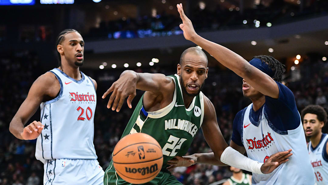 Dec 21, 2024; Milwaukee, Wisconsin, USA; Milwaukee Bucks forward Khris Middleton (22) battles for the ball against Washington Wizards forward Bilal Coulibaly (0) in the first quarter at Fiserv Forum. Mandatory Credit: Benny Sieu-Imagn Images