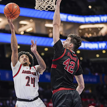 Mar 13, 2025; Charlotte, NC, USA;  Louisville Cardinals guard Chucky Hepburn (24) goes to the basket against Stanford Cardinal forward Maxime Raynaud (42) during the second half at Spectrum Center. Mandatory Credit: Jim Dedmon-Imagn Images