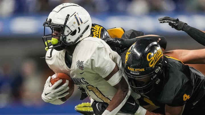 Decatur Central Hawks N'po Dodo (11) rushes away from Fort Wayne Snider Panthers Brandon Logan (4) on Friday, Nov. 24, 2023, during the IHSAA Class 3A football state championship game at Lucas Oil Stadium in Indianapolis. The Fort Wayne Snider Panthers lead at the half against the Decatur Central Hawks, 7-6.