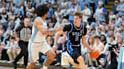 Duke Blue Devils forward Cooper Flagg dribbles as North Carolina Tar Heels guard Elliot Cadeau defends.