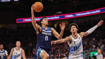 Dec 23, 2024; Atlanta, Georgia, USA; Minnesota Timberwolves forward Josh Minott (8) shoots past Atlanta Hawks forward Jalen Johnson (1) in the fourth quarter at State Farm Arena. Mandatory Credit: Brett Davis-Imagn Images