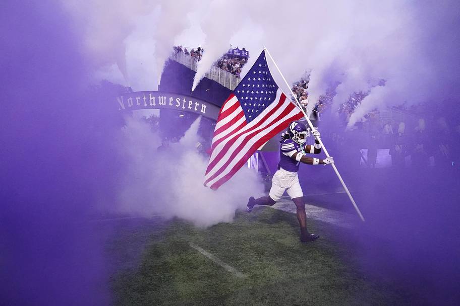 Wildcats defensive back Ore Adeyi leads the team onto the field in their season opener against South Dakota State.