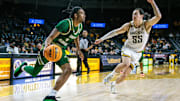 Jan 6, 2025; Wichita, Kansas, USA; South Florida Bulls guard Kobe Knox (4) drives to the basket around Wichita State Shockers guard Bijan Cortes (55) during the first half at Charles Koch Arena. Mandatory Credit: William Purnell-Imagn Images