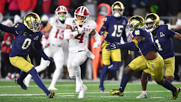 Dec 20, 2024; Notre Dame, Indiana, USA; Indiana Hoosiers wide receiver Donaven McCulley (1) runs against Notre Dame Fighting Irish safety Xavier Watts (0) and Notre Dame Fighting Irish safety Adon Shuler (8) during the first half at Notre Dame Stadium. Mandatory Credit: Matt Cashore-Imagn Images