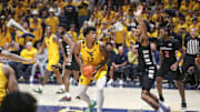 Feb 19, 2025; Morgantown, West Virginia, USA; West Virginia Mountaineers forward Amani Hansberry (13) controls the ball against Cincinnati Bearcats forward Dillon Mitchell (23) during the second half at WVU Coliseum. Mandatory Credit: Ben Queen-Imagn Images