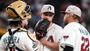 Arizona Diamondbacks pitcher Merrill Kelly (29) chats with infielder Josh Naylor (22) and catcher Jose Herrera (11) as he pitches against the Colorado Rockies at Chase Field in Phoenix on May 18, 2025.
