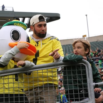 A young Oregon fan dressed as a Duck tries to get the official Oregon Duck’s attention from the stands before the Oregon Spring Game at Autzen Stadium Saturday, April 27, 2024.