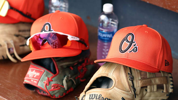 Mar 11, 2024; Tampa, Florida, USA;  A detailed view of Baltimore Orioles baseball hats and gloves in the dugout during the first inning against the New York Yankees at George M. Steinbrenner Field. Mandatory Credit: Kim Klement Neitzel-Imagn Images