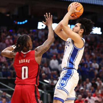 Mar 31, 2024; Dallas, TX, USA; Duke Blue Devils guard Jared McCain (0) shoots against North Carolina State Wolfpack guard DJ Horne (0) in the first half in the finals of the South Regional of the 2024 NCAA Tournament at American Airline Center. 