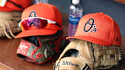Mar 11, 2024; Tampa, Florida, USA;  A detailed view of Baltimore Orioles baseball hats and gloves in the dugout during the first inning against the New York Yankees at George M. Steinbrenner Field.