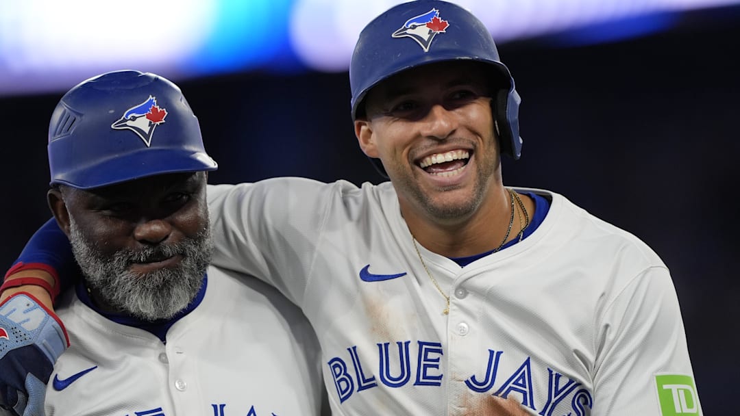 Aug 25, 2025; Toronto, Ontario, CAN; Toronto Blue Jays left fielder George Springer (right) and third base coach Carlos Febles (left) smile after the eighth inning against the Minnesota Twins at Rogers Centre.