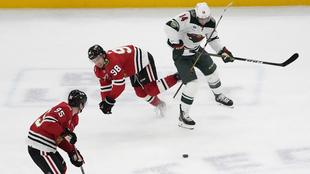 Nov 26, 2025; Chicago, Illinois, USA; Minnesota Wild center Joel Eriksson Ek (14) checks Chicago Blackhawks center Connor Bedard (98)