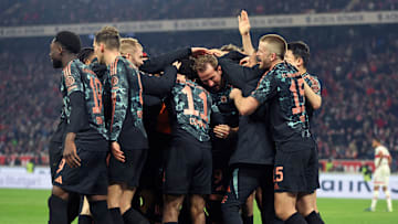 Bayern Munich players celebrating after scoring a goal against VfB Stuttgart.