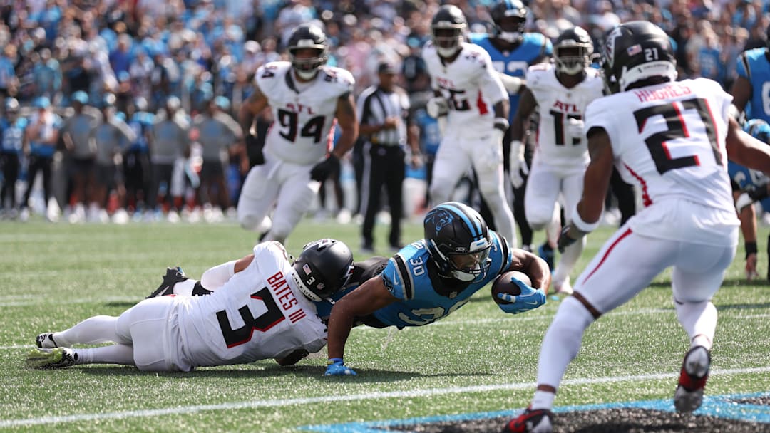 Sep 21, 2025; Charlotte, North Carolina, USA; Carolina Panthers running back Chuba Hubbard (30) reaches for yardage during the second half against the Atlanta Falcons at Bank of America Stadium. 