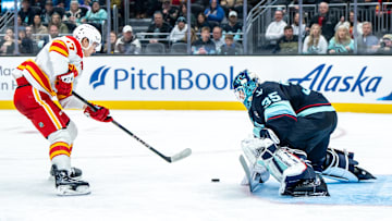 Feb 2, 2025; Seattle, Washington, USA;  Seattle Kraken goalie Joey Daccord (35) makes a save on a shot by Calgary Flames forward Yegor Sharangovich (17) during the third period at Climate Pledge Arena. Mandatory Credit: Stephen Brashear-Imagn Images