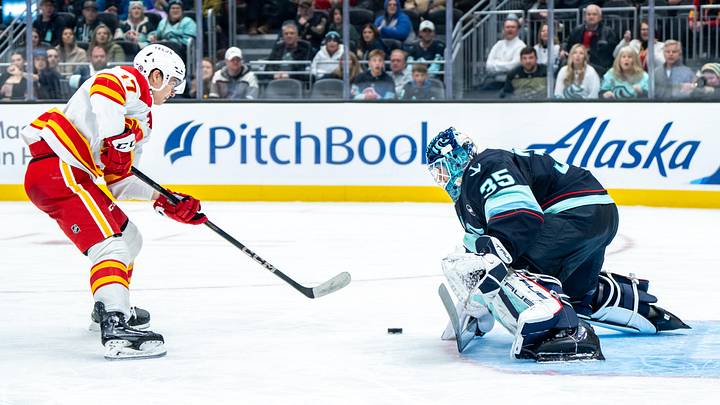 Feb 2, 2025; Seattle, Washington, USA;  Seattle Kraken goalie Joey Daccord (35) makes a save on a shot by Calgary Flames forward Yegor Sharangovich (17) during the third period at Climate Pledge Arena. Mandatory Credit: Stephen Brashear-Imagn Images