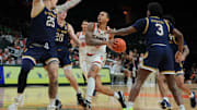 Feb 1, 2025; Coral Gables, Florida, USA; Miami Hurricanes guard Matthew Cleveland (0) drives to the basket against Notre Dame Fighting Irish forward Nikita Konstantynovskyi (25), guard J.R. Konieczny (20) and guard Markus Burton (3) during the second half at Watsco Center. Mandatory Credit: Sam Navarro-Imagn Images