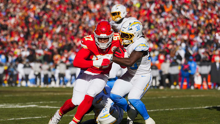 Dec 14, 2025; Kansas City, Missouri, USA; Kansas City Chiefs defensive end Ashton Gillotte (97) is tackled by Los Angeles Chargers running back Kimani Vidal (30) following an interception  during the second quarter at GEHA Field at Arrowhead Stadium. Mandatory Credit: Jay Biggerstaff-Imagn Images