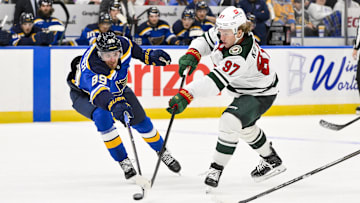Nov 19, 2024; St. Louis, Missouri, USA;  Minnesota Wild left wing Kirill Kaprizov (97) shoots as St. Louis Blues left wing Pavel Buchnevich (89) defends during the third period at Enterprise Center. Mandatory Credit: Jeff Curry-Imagn Images