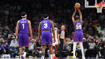 Mar 2, 2025; Phoenix, Arizona, USA; Phoenix Suns guard Devin Booker (1) and Phoenix Suns guard Bradley Beal (3) watch as Phoenix Suns forward Kevin Durant (35) shoots a free throw against the Minnesota Timberwolves during the first half at Footprint Center. Mandatory Credit: Joe Camporeale-Imagn Images
