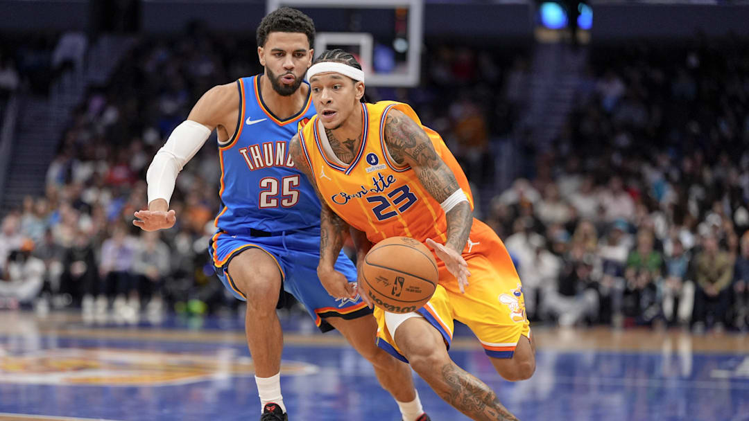 Nov 15, 2025; Charlotte, North Carolina, USA; Charlotte Hornets guard Tre Mann (23) drives to the basket against Oklahoma City Thunder guard Ajay Mitchell (25) during the first half  at Spectrum Center. Mandatory Credit: Jim Dedmon-Imagn Images