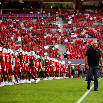 Aug 29, 2024; Raleigh, North Carolina, USA; North Carolina State Wolfpack head coach Dave Doeren between his players before the first half of the game against Western Carolina Catamounts at Carter-Finley Stadium. Mandatory Credit: Jaylynn Nash-Imagn Images