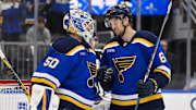 Mar 23, 2025; St. Louis, Missouri, USA;  St. Louis Blues goaltender Jordan Binnington (50) and defenseman Philip Broberg (6) celebrate after the Blues defeated the Nashville Predators at Enterprise Center. Mandatory Credit: Jeff Curry-Imagn Images