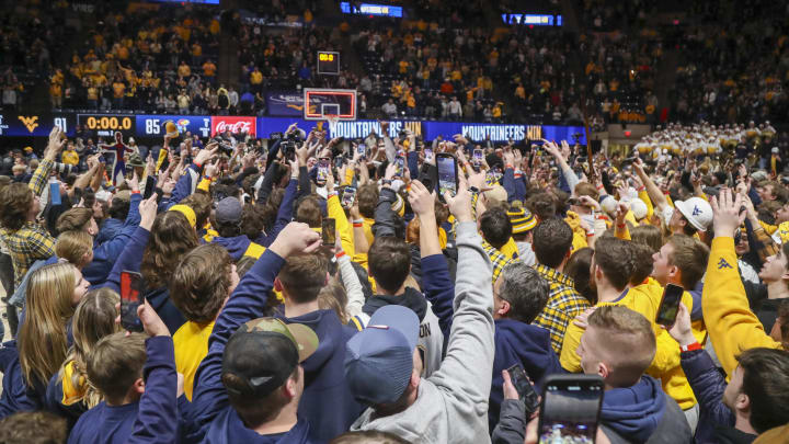 Jan 20, 2024; Morgantown, West Virginia, USA; West Virginia Mountaineers students rush the floor after beating the Kansas Jayhawks at WVU Coliseum. Mandatory Credit: Ben Queen-USA TODAY Sports