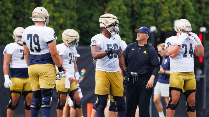 Notre Dame offensive line coach Joe Rudolph, second from right, talks to offensive lineman Aamil Wagner (59) during a Notre Dame football practice at Irish Athletic Center on Thursday, Aug. 1, 2024, in South Bend.