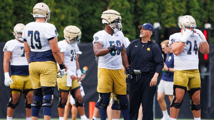 Notre Dame offensive line coach Joe Rudolph, second from right, talks to offensive lineman Aamil Wagner (59) during a Notre Dame football practice at Irish Athletic Center on Thursday, Aug. 1, 2024, in South Bend.