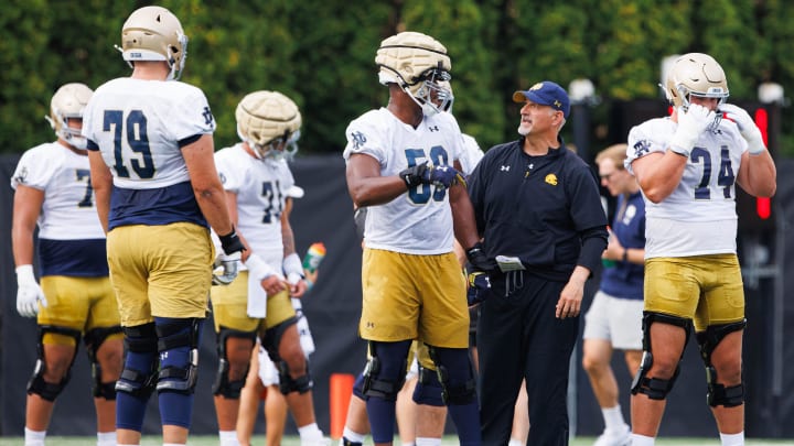 Notre Dame offensive line coach Joe Rudolph, second from right, talks to offensive lineman Aamil Wagner (59) during a Notre Dame football practice at Irish Athletic Center on Thursday, Aug. 1, 2024, in South Bend.