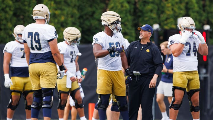 Notre Dame offensive line coach Joe Rudolph, second from right, talks to offensive lineman Aamil Wagner (59) during a Notre Dame football practice at Irish Athletic Center on Thursday, Aug. 1, 2024, in South Bend.