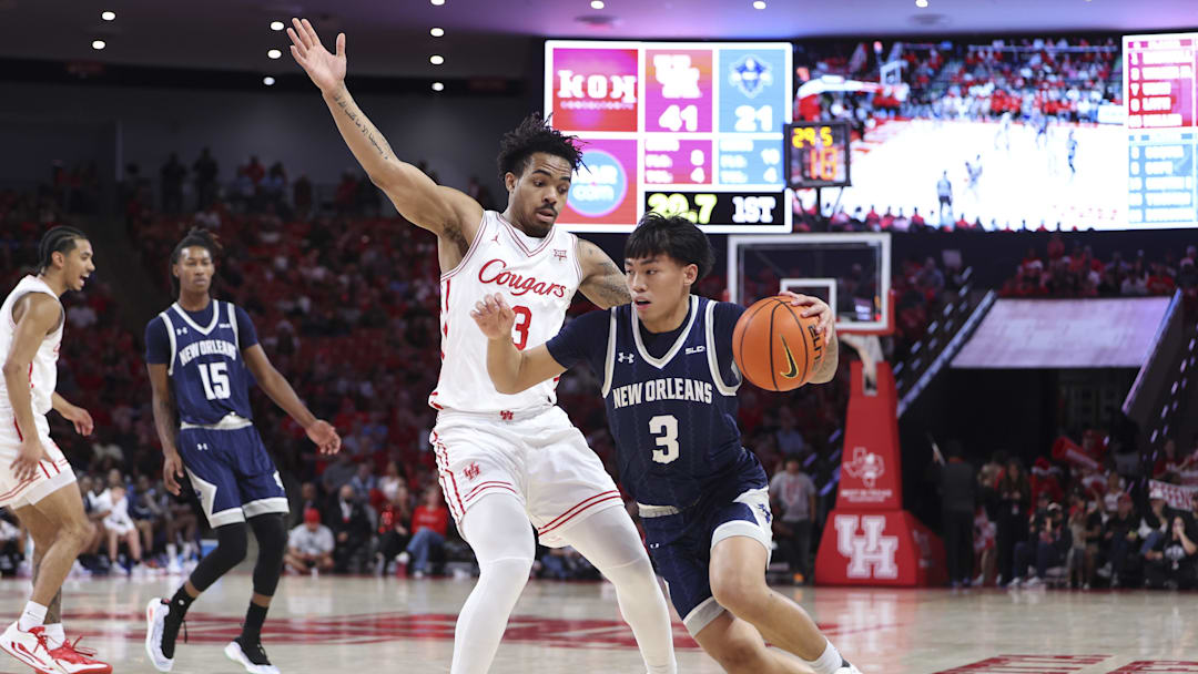 Dec 13, 2025; Houston, Texas, USA; New Orleans Privateers guard Irish Coquia (3) drives with the ball as Houston Cougars guard Ramon Walker Jr. (3) defends during the first half at Fertitta Center. Mandatory Credit: Troy Taormina-Imagn Images